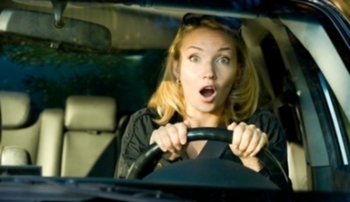 Vyděšená žena za volantem automobilu