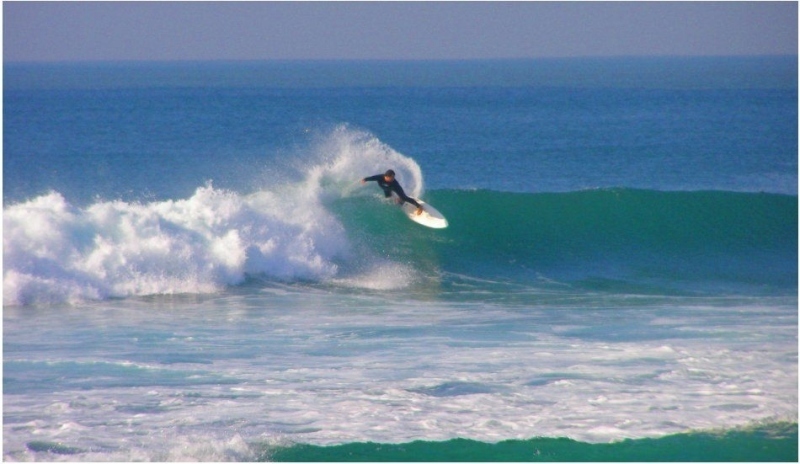 Muž surfuje na vlnách