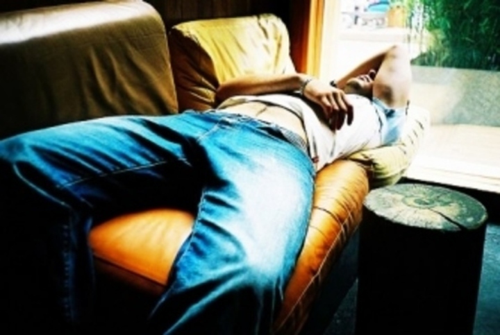 Muž ležící na pohovce 