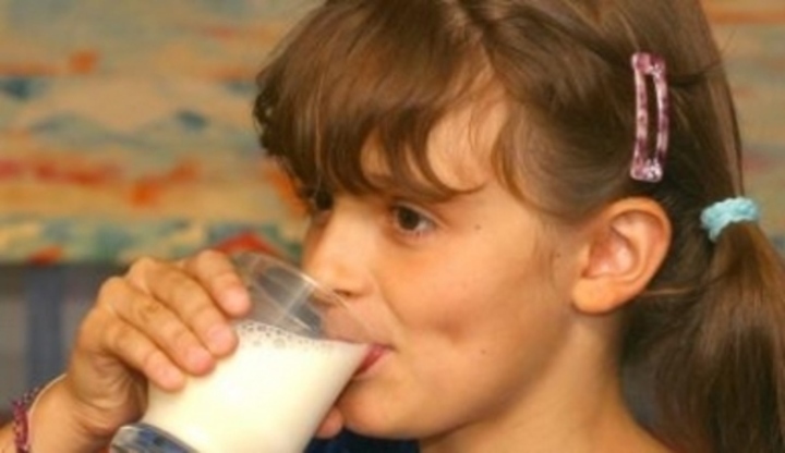 Dívka pijící sklenici mléka