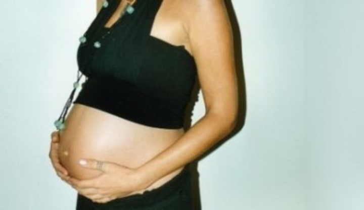 Žena držící si těhotenské bříško 