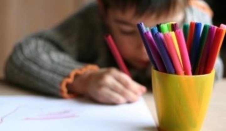 Dítě kreslící barevnými pastelkami 