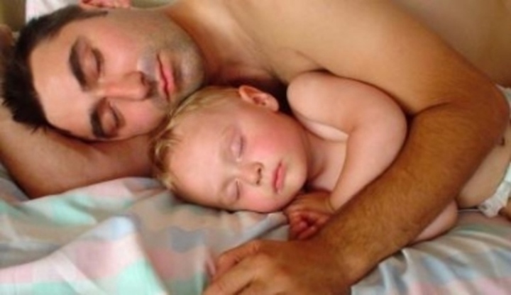 Ležící muž objímající své dítě 