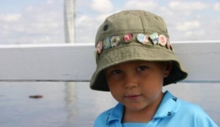 Chlapec s kloboukem s odznaky na hlavě 
