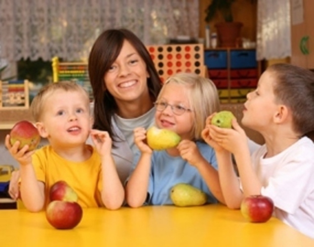 Žena s dětmi co drží ovoce 