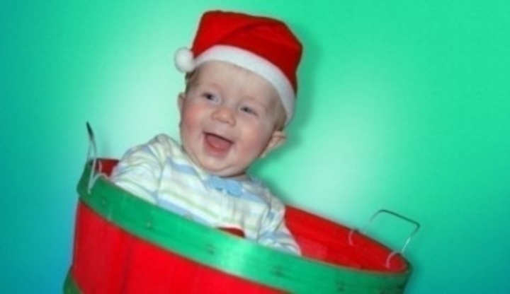 Smějící se dítě s vánoční čepičkou na hlavě