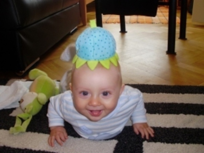 Dítě s plyšovou hračkou na hlavě 