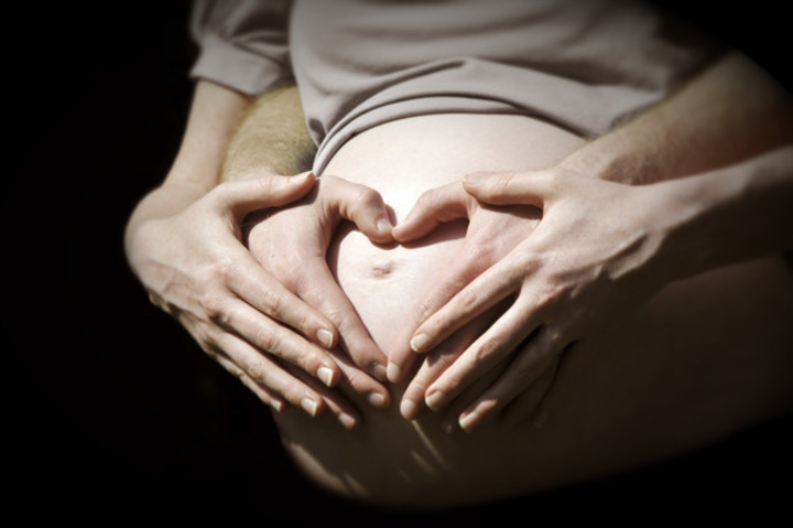 Ruce položené na těhotenském bříšku 