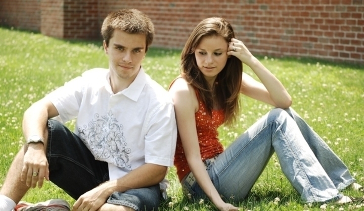 Dívka s chlapcem sedící na trávě 