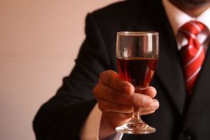 Ruka držící sklenici červeného vína