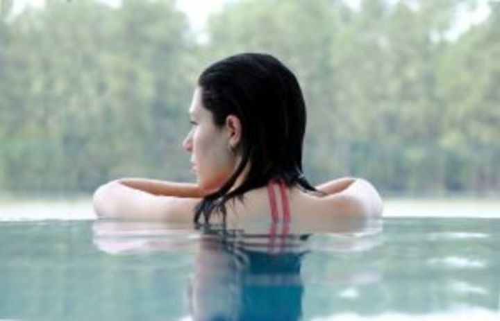 Žena opírající se o okraj bazénu 