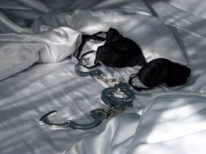 Pouta s černou podprsenkou ležící na posteli