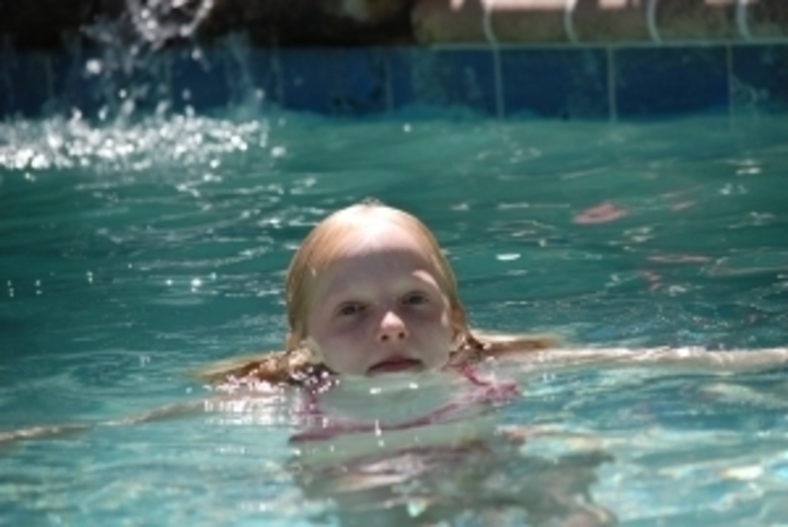 Holčička plavající v bazénu