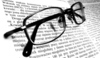 Dioptrické brýle ležící na otevřené knize 