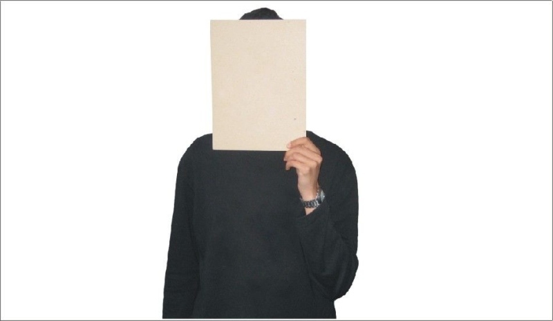Muž s listem papíru před obličejem 